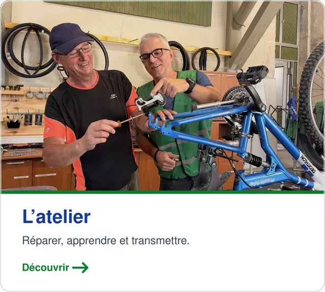 Deux mécanos bénévoles autour d’un vélo à l’atelier