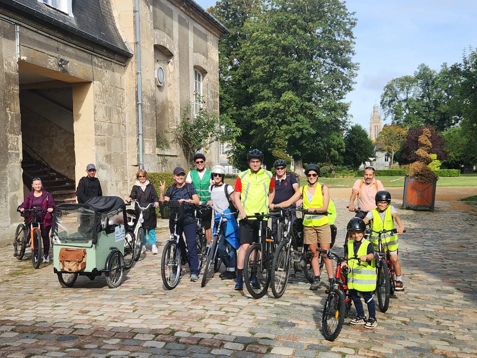 Un groupe de cyclistes devant les Grandes Écuries du Roy