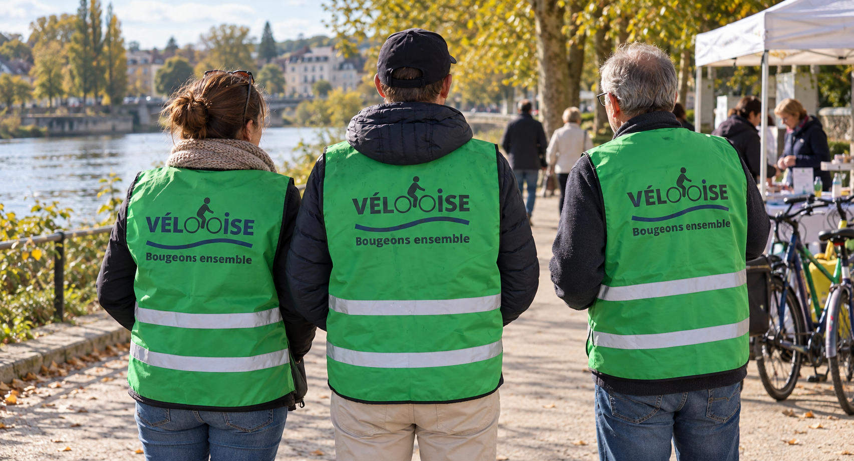 Trois bénévoles de dos en chasuble verte VélOOise au bord de l’Oise